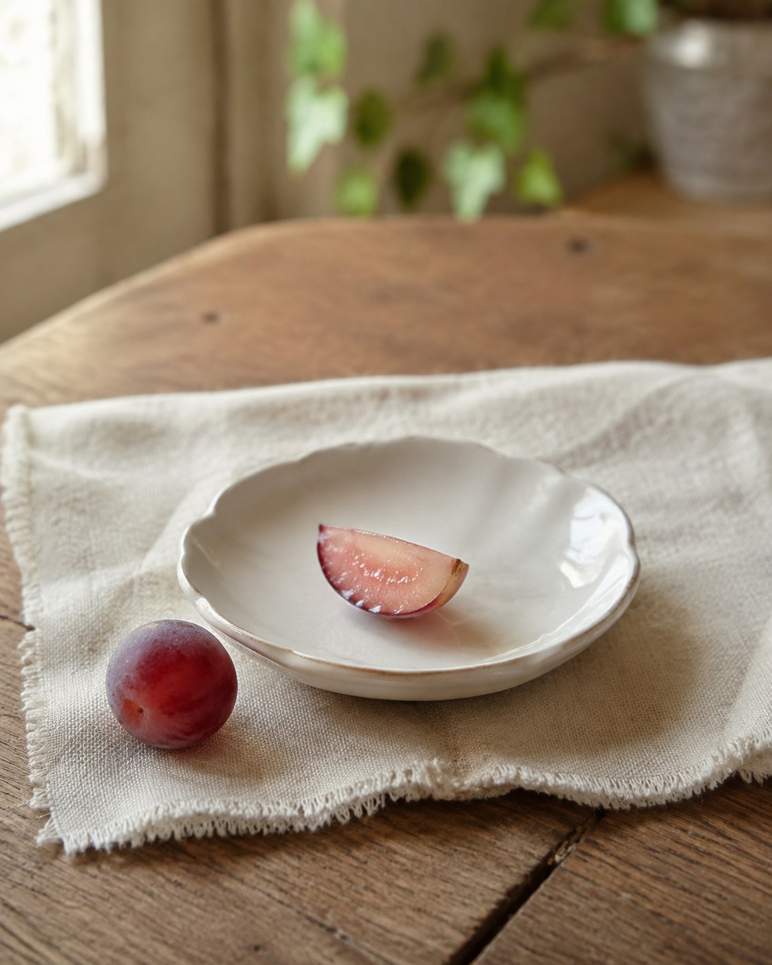 A small piece of grape beside a sprig of cilantro on a wooden surface